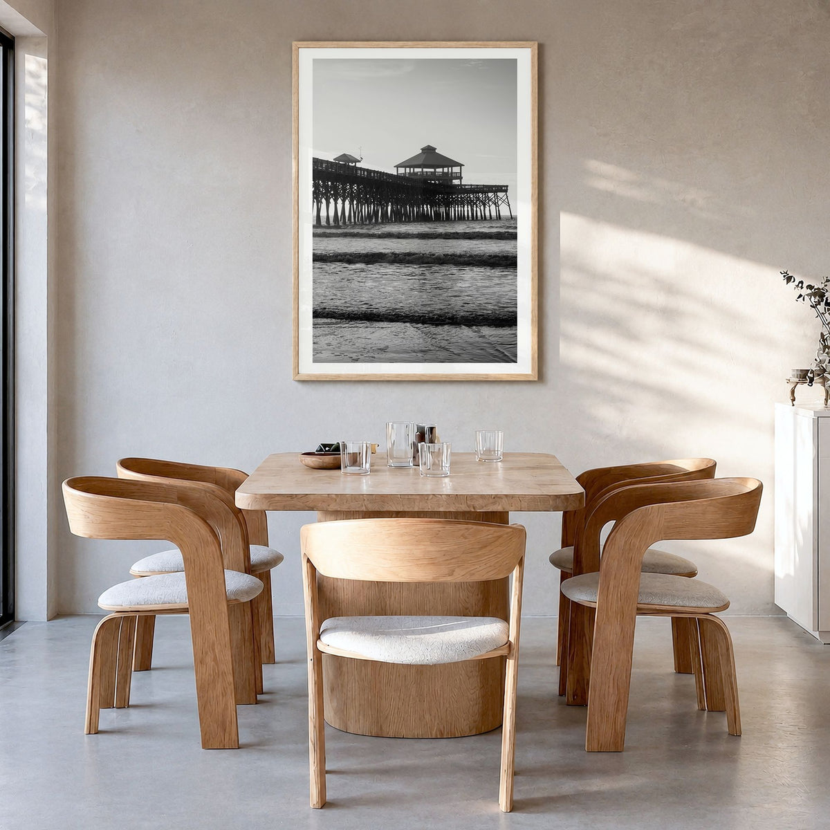 Folly Beach Photo Poster in a natural wood frame, hanging in a dining room, white border