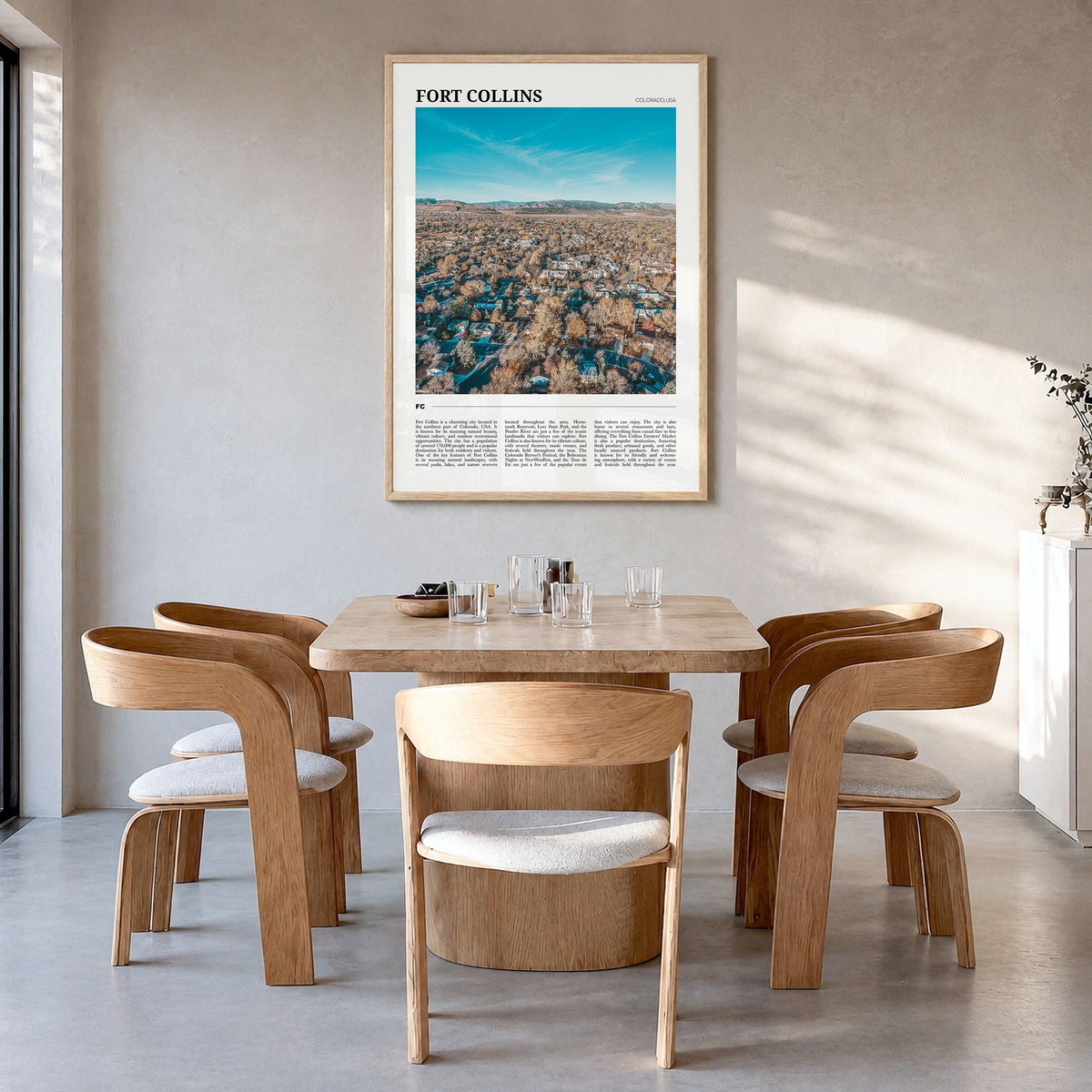 Fort Collins Travel Poster in a natural wood frame, hanging in a dining room