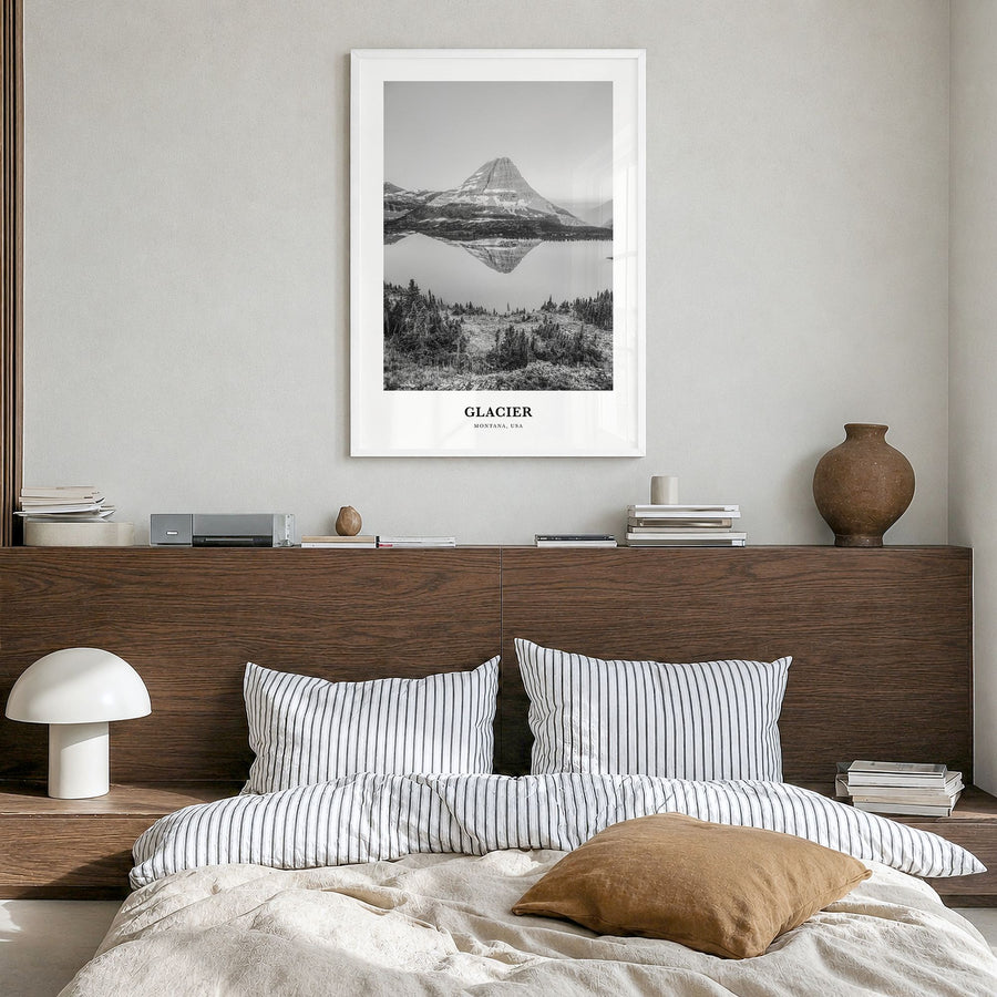 Glacier National Park Classic Poster in a white wood frame, hanging in a bedroom