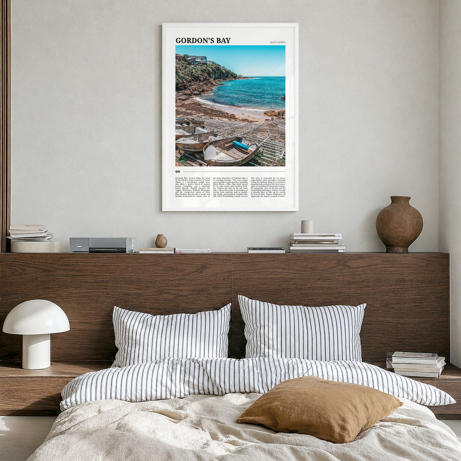 Gordon's Bay Travel Poster in a white wood frame, hanging in a bedroom