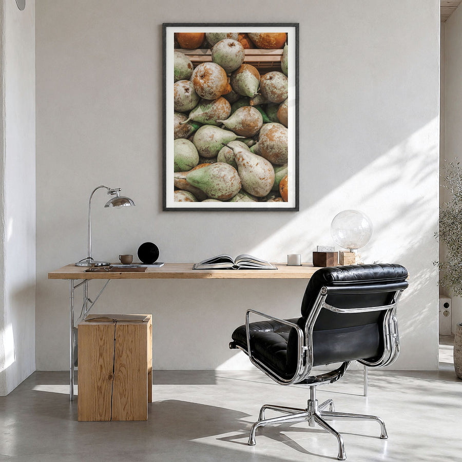 Green Pears Photo Poster in a black wood frame, hanging in a bright home office, white border