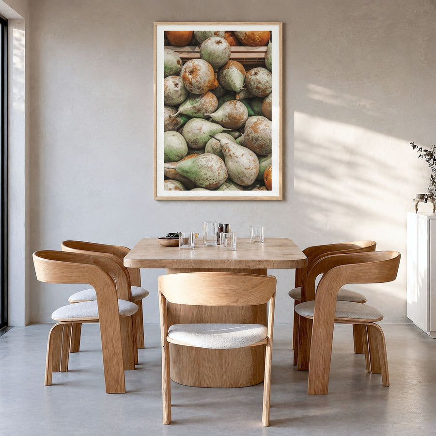 Green Pears Photo Poster in a natural wood frame, hanging in a dining room, white border