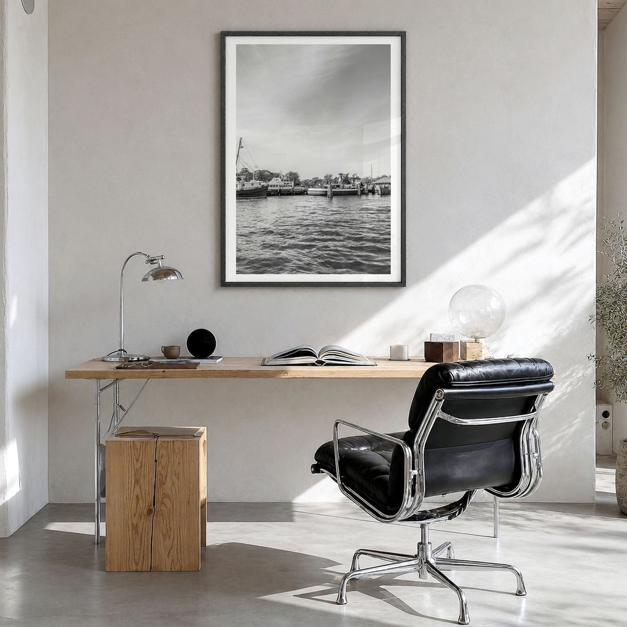 Greenport Photo Poster in a black wood frame, hanging in a bright home office, white border