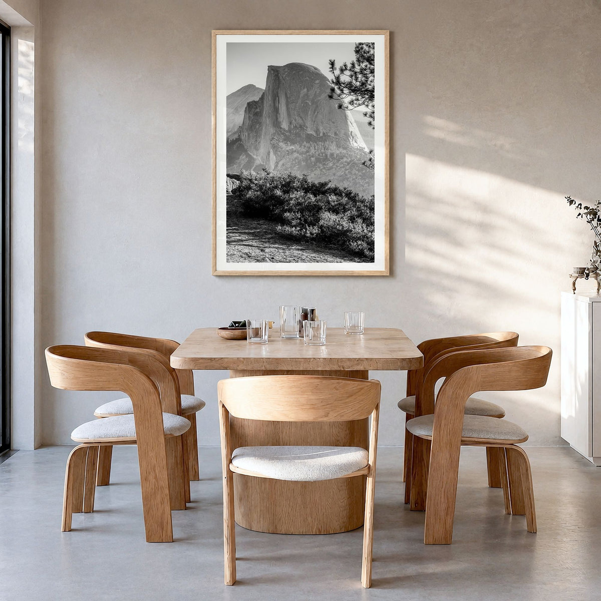 Half Dome Photo Poster in a natural wood frame, hanging in a dining room, white border
