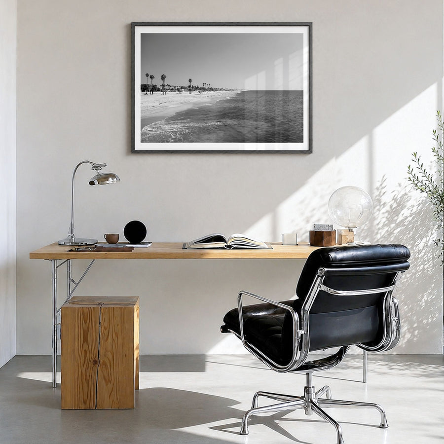 Hermosa Beach Photo Poster in a black wood frame, hanging in a bright home office, white border