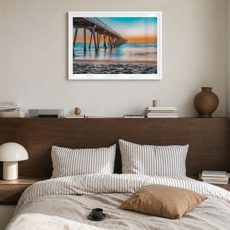 Hermosa Beach Photo Poster in a white wood frame, hanging in a bedroom, white border