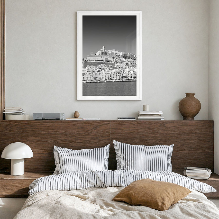 Ibiza Photo Poster in a white wood frame, hanging in a bedroom, white border