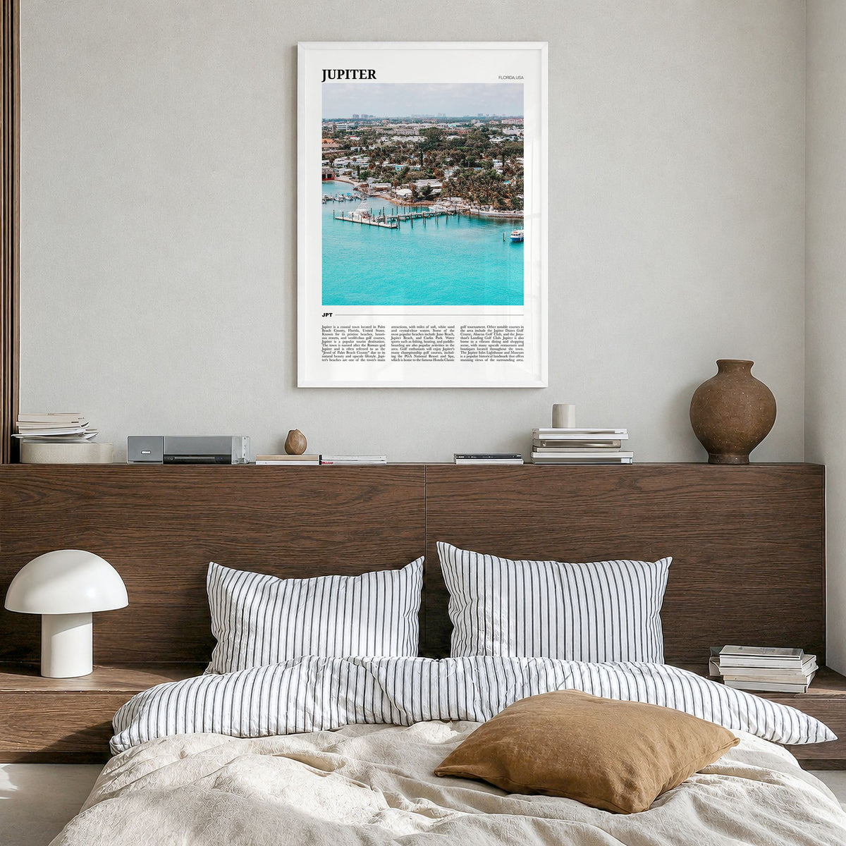 Jupiter Travel Poster in a white wood frame, hanging in a bedroom
