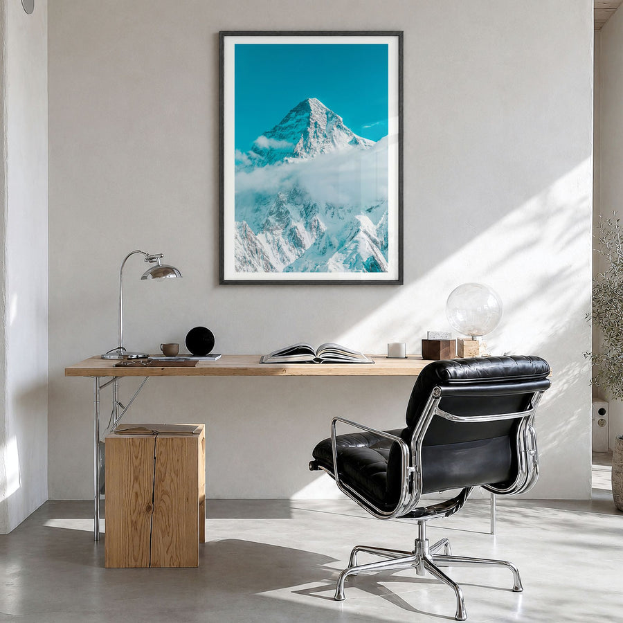 K2 Photo Poster in a black wood frame, hanging in a bright home office, white border