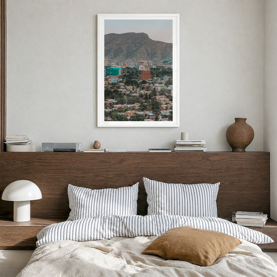 Kabul Photo Poster in a white wood frame, hanging in a bedroom, white border