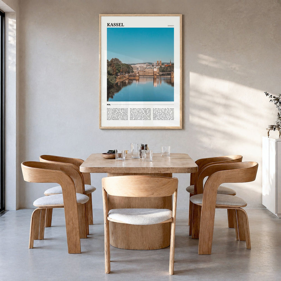 Kassel Travel Poster in a natural wood frame, hanging in a dining room