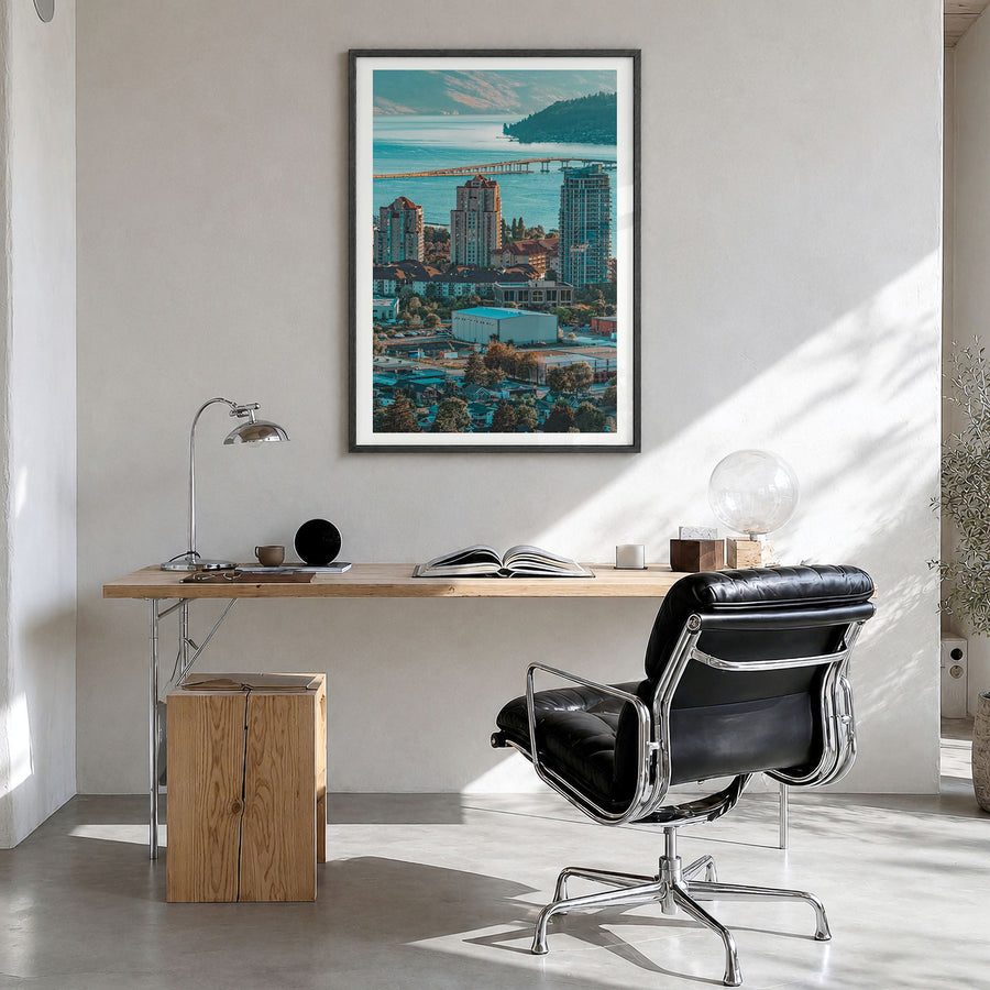 Kelowna Photo Poster in a black wood frame, hanging in a bright home office, white border