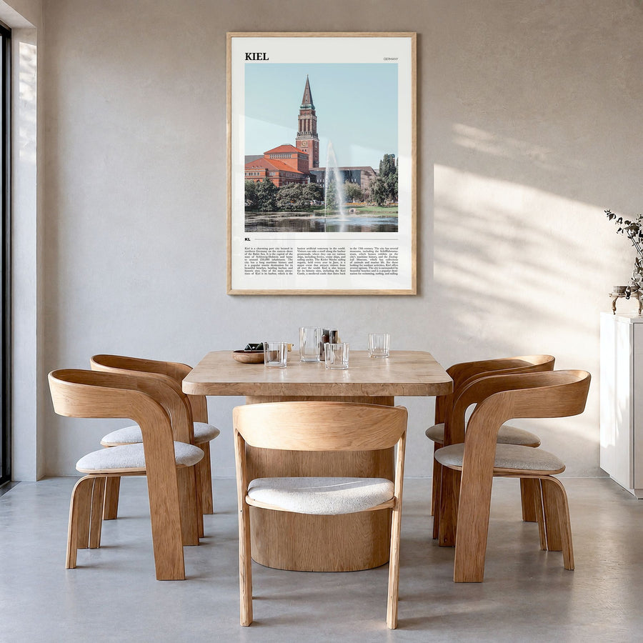 Kiel Travel Poster in a natural wood frame, hanging in a dining room