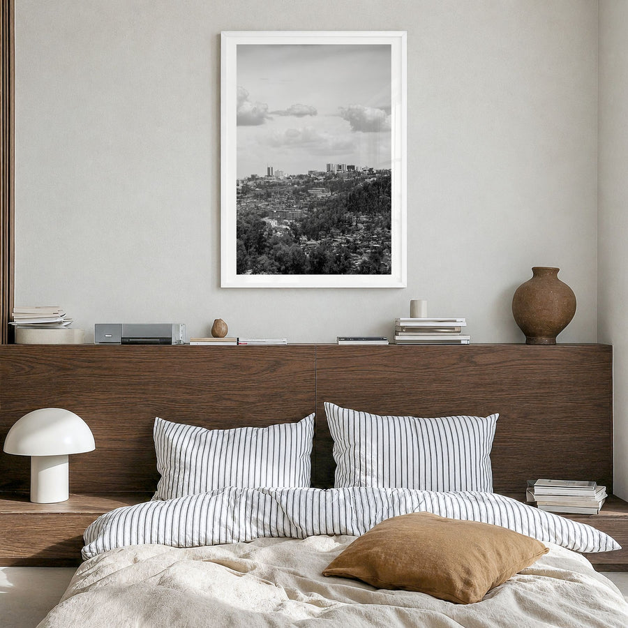 Kigali Photo Poster in a white wood frame, hanging in a bedroom, white border
