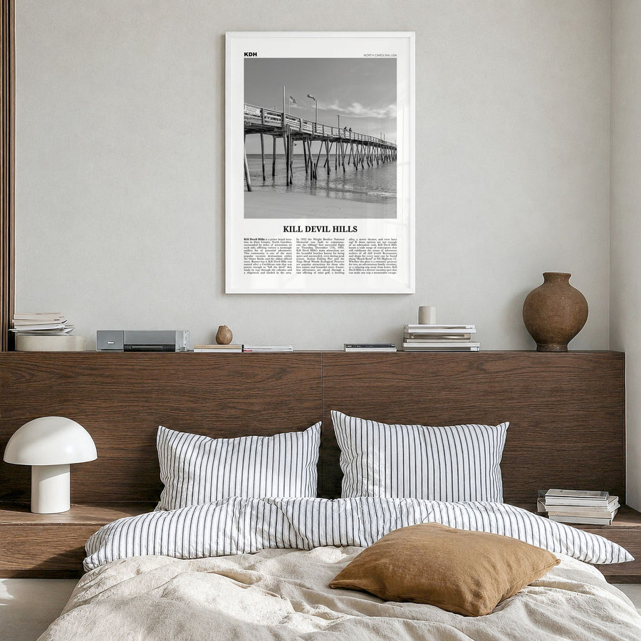 Kill Devil Hills Newspaper Poster in a white wood frame, hanging in a bedroom