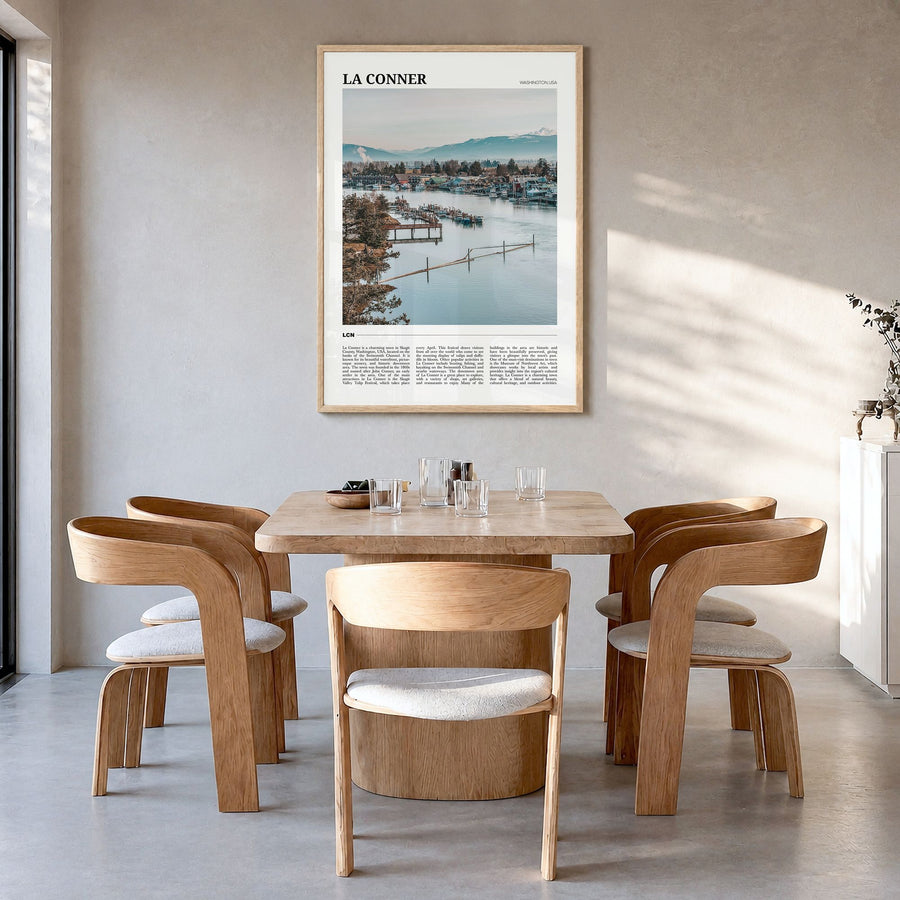 La Conner Travel Poster in a natural wood frame, hanging in a dining room