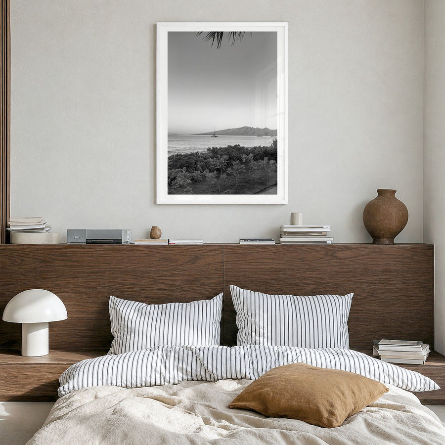 Lahaina Photo Poster in a white wood frame, hanging in a bedroom, white border