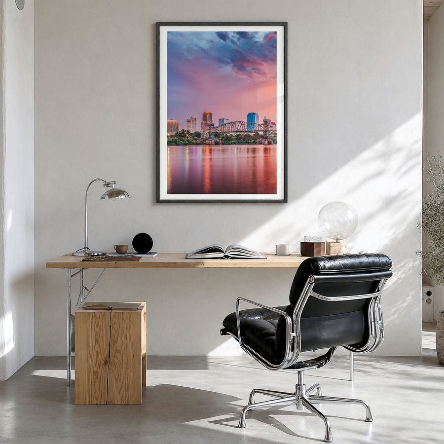 Little Rock Photo Poster in a black wood frame, hanging in a bright home office, white border