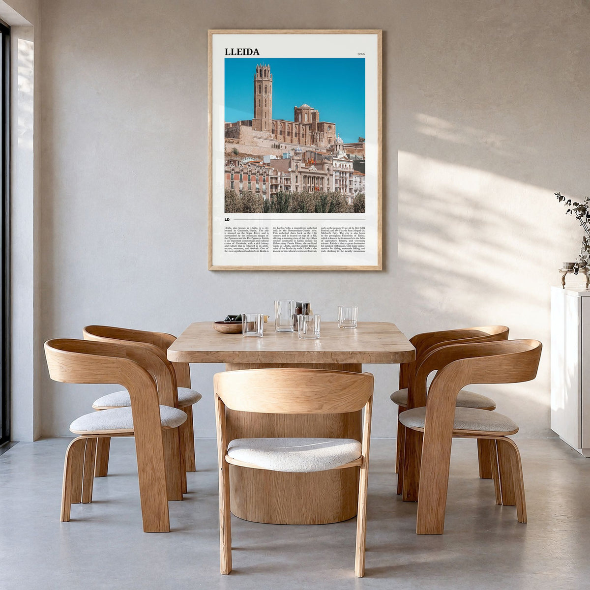 Lleida Travel Poster in a natural wood frame, hanging in a dining room