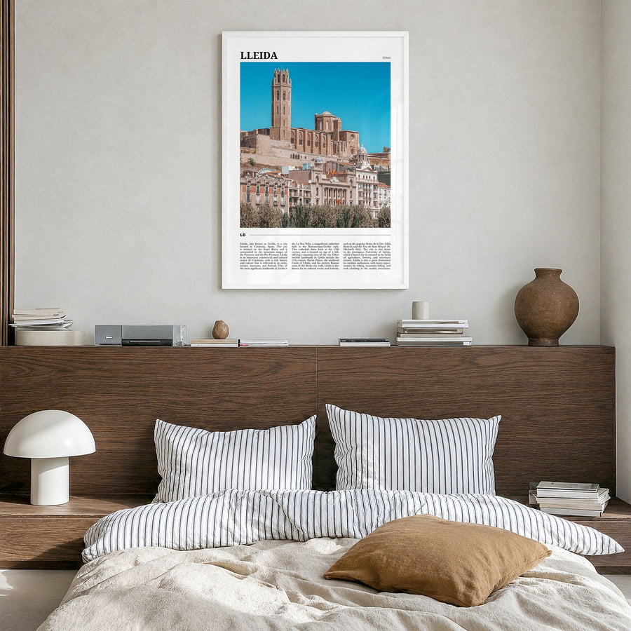 Lleida Travel Poster in a white wood frame, hanging in a bedroom