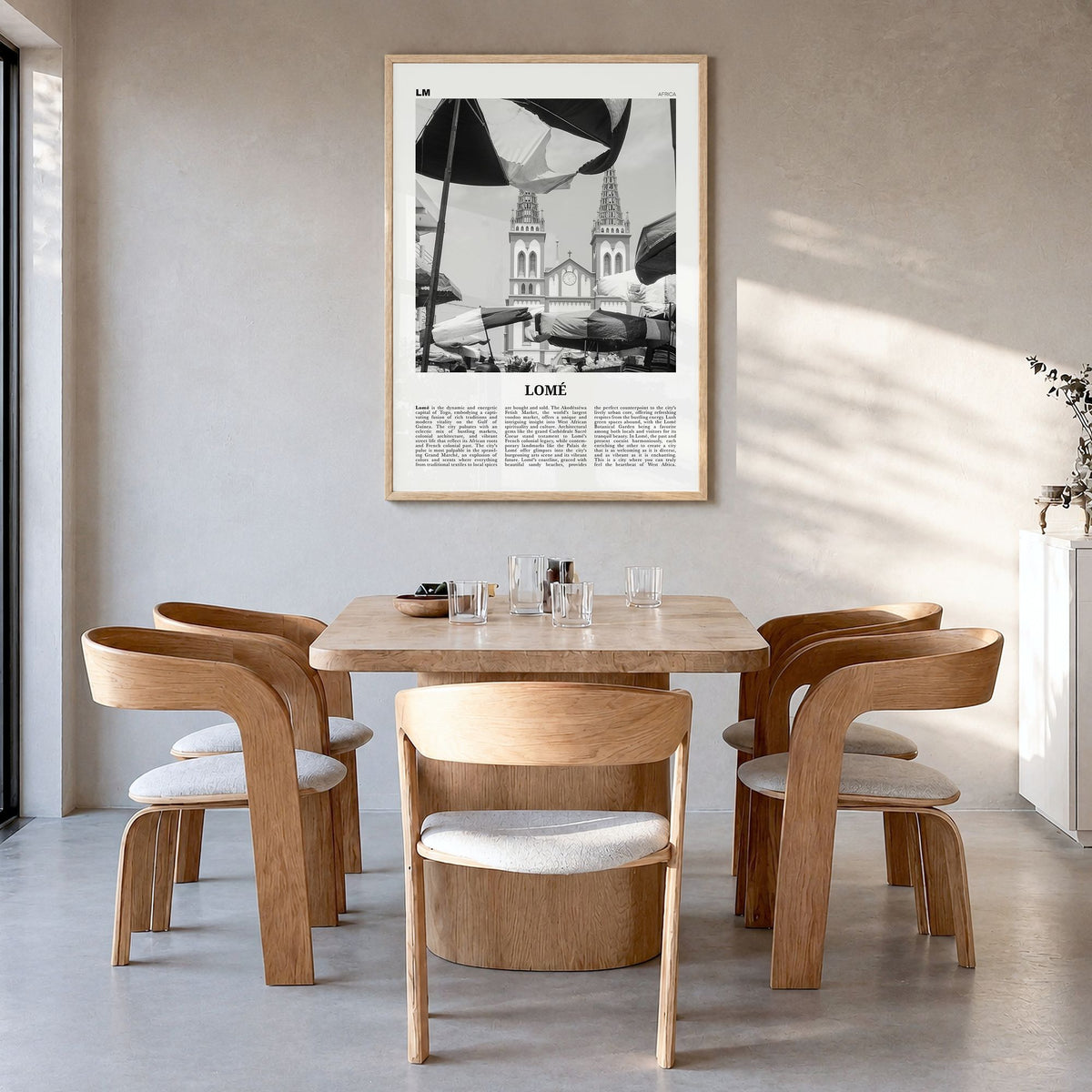 Lomé Newspaper Poster in a natural wood frame, hanging in a dining room