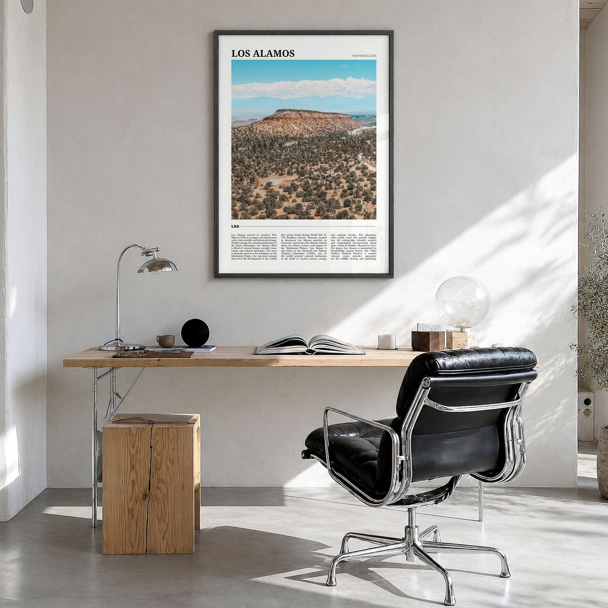 Los Alamos Travel Poster in a black wood frame, hanging in a bright home office