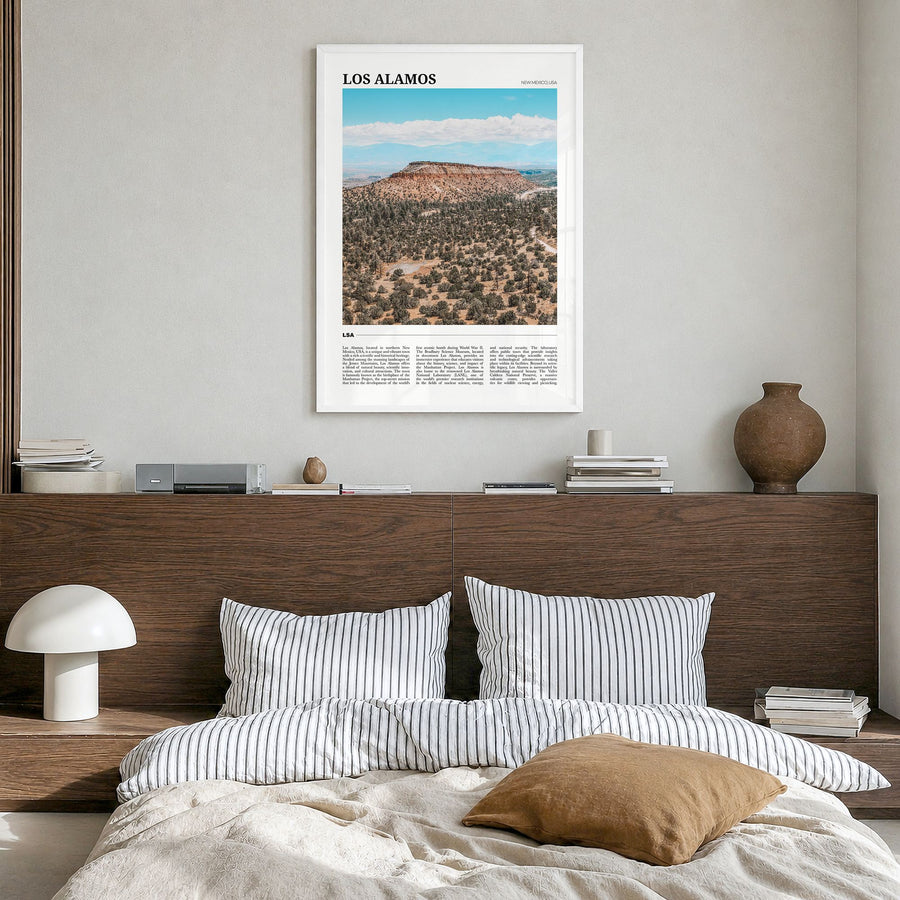 Los Alamos Travel Poster in a white wood frame, hanging in a bedroom