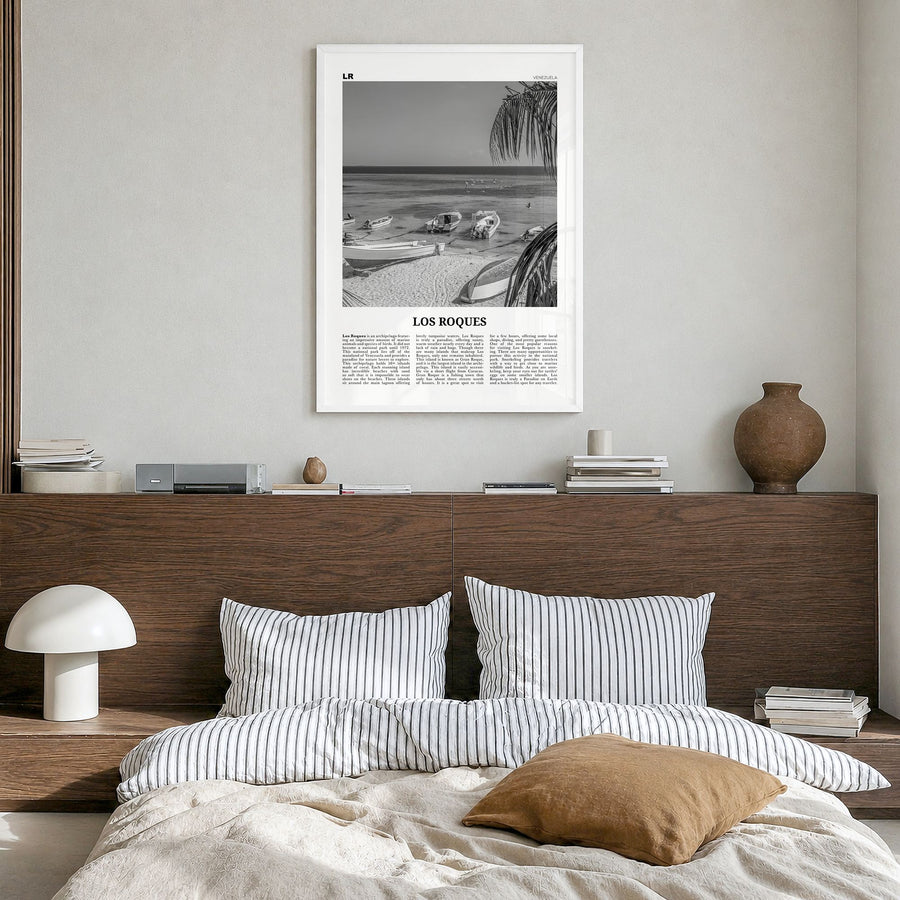 Los Roques Newspaper Poster in a white wood frame, hanging in a bedroom