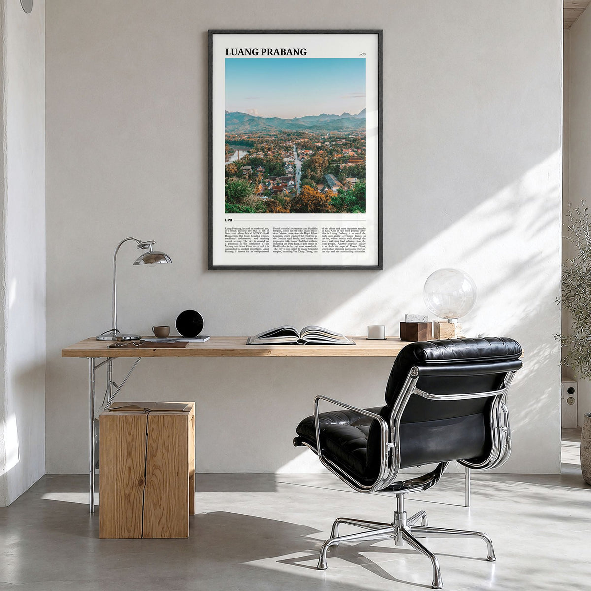 Luang Prabang Travel Poster in a black wood frame, hanging in a bright home office