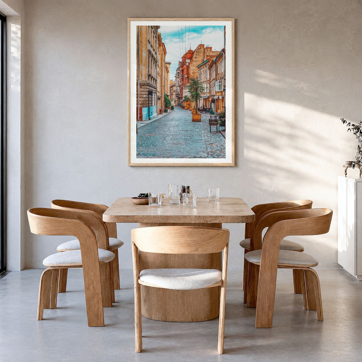 Lviv Photo Poster in a natural wood frame, hanging in a dining room, white border