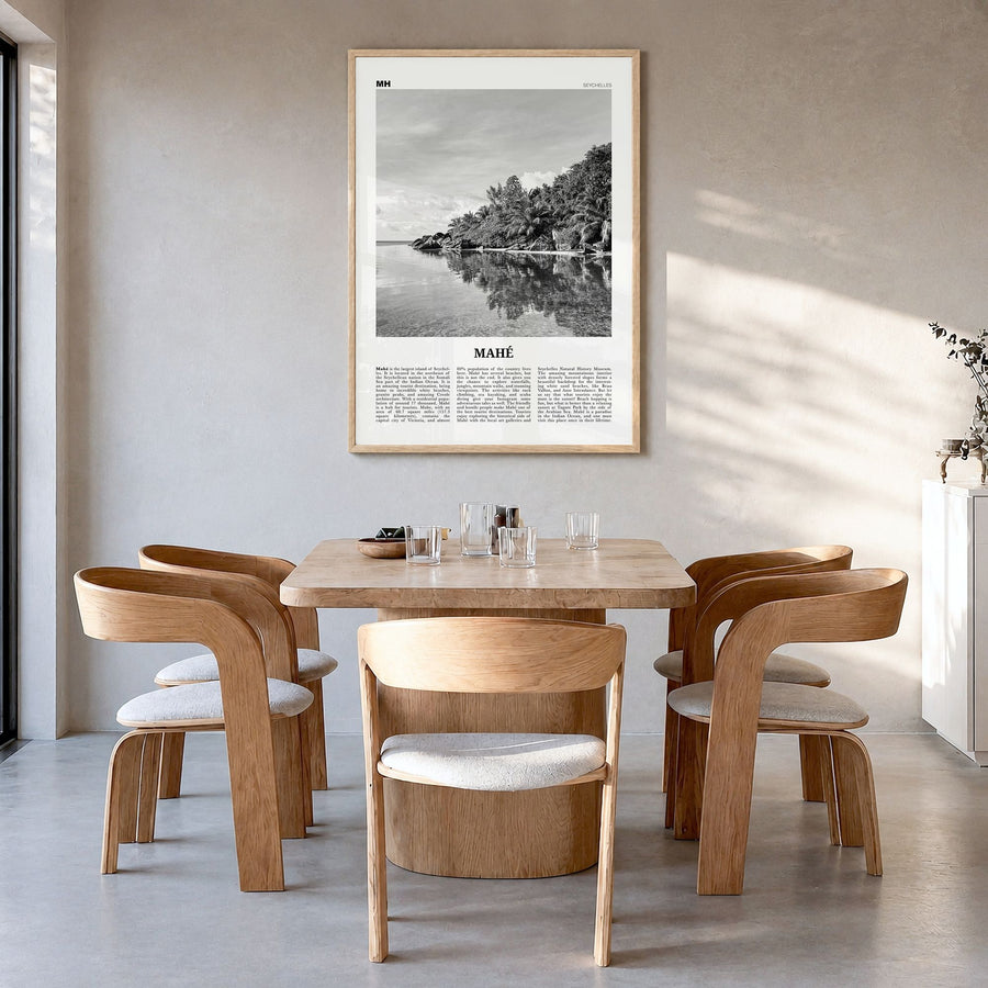 Mahé Newspaper Poster in a natural wood frame, hanging in a dining room