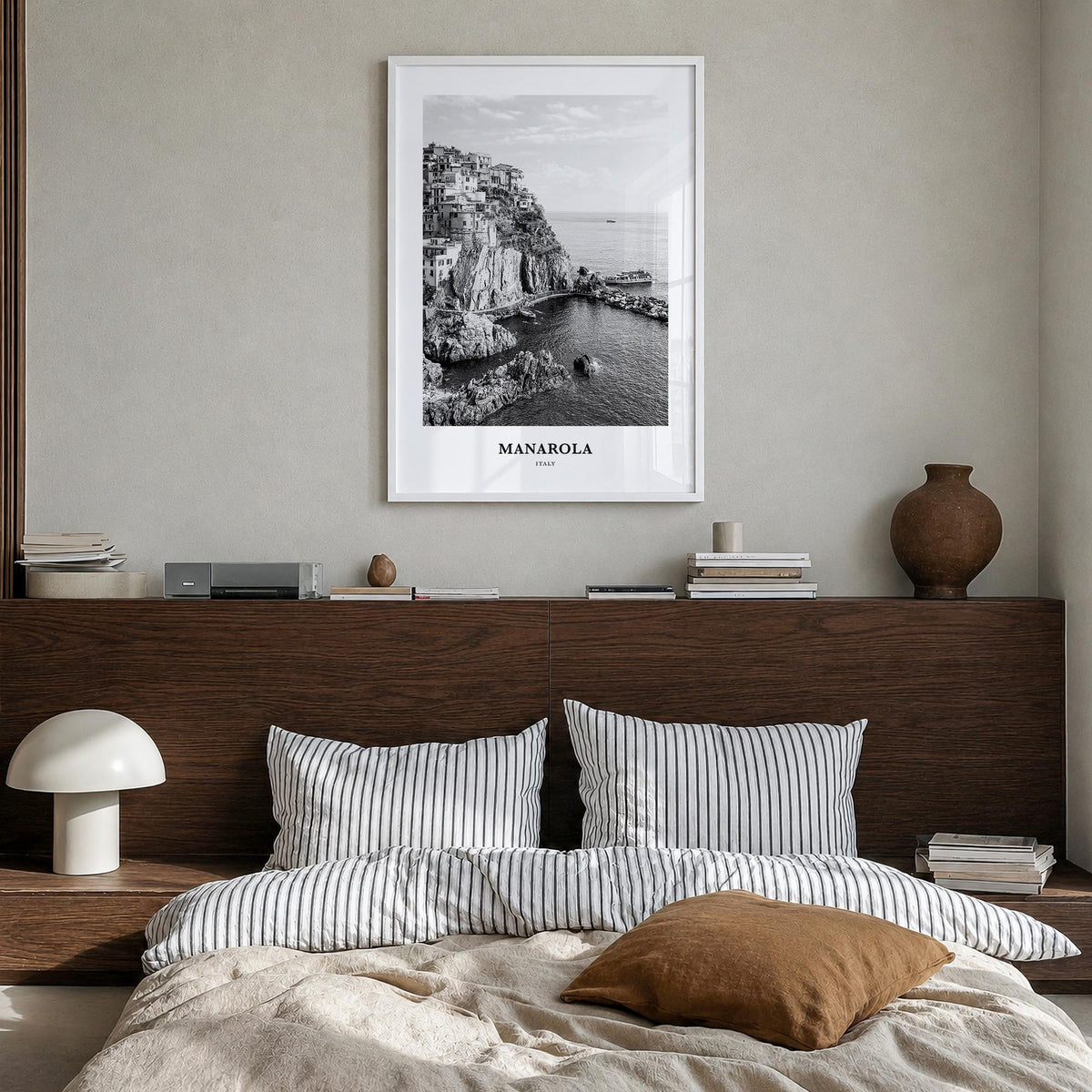 Manarola black & white classic poster of Italy – vertical wall art in white wood frame, hanging on wall