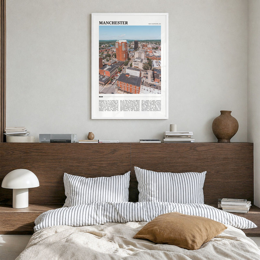 Manchester, New Hampshire Travel Poster in a white wood frame, hanging in a bedroom