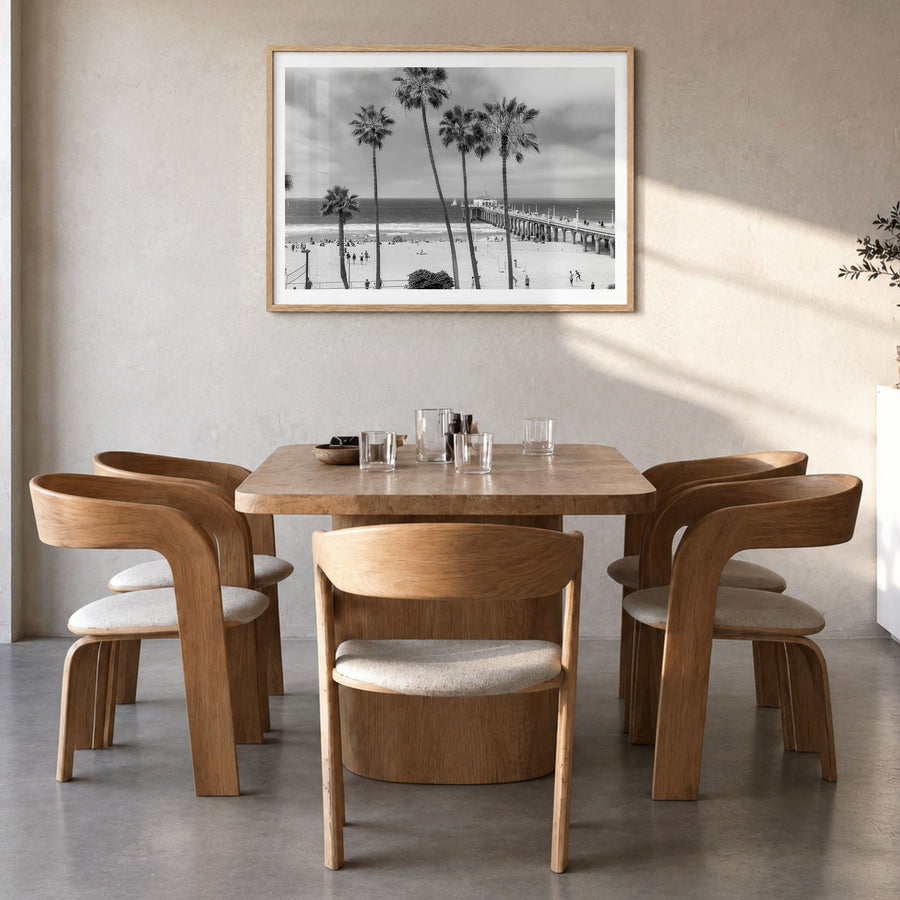 Manhattan Beach Photo Poster in a natural wood frame, hanging in a dining room, white border