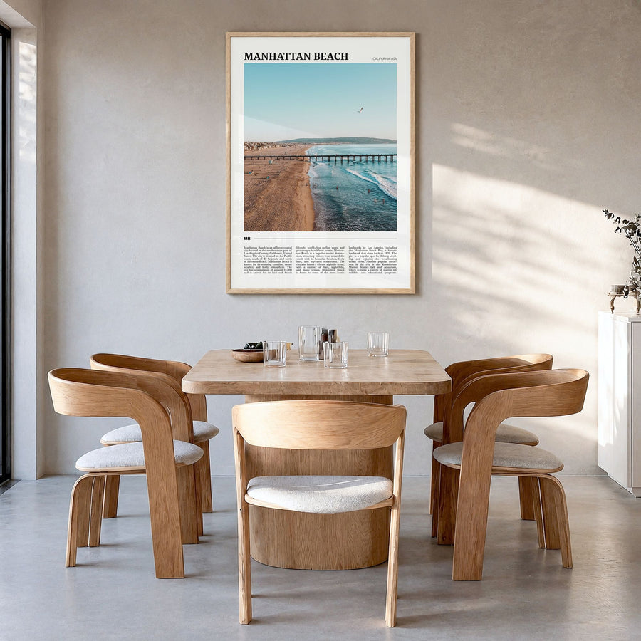 Manhattan Beach Travel Poster in a natural wood frame, hanging in a dining room
