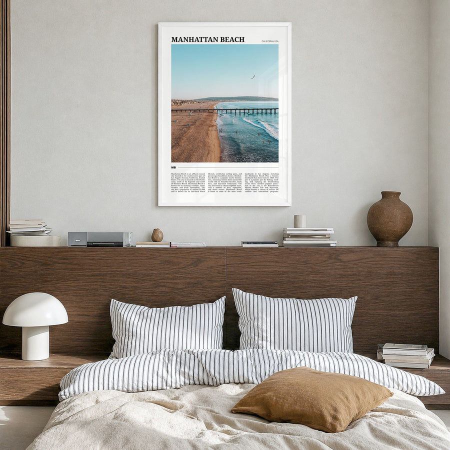 Manhattan Beach Travel Poster in a white wood frame, hanging in a bedroom
