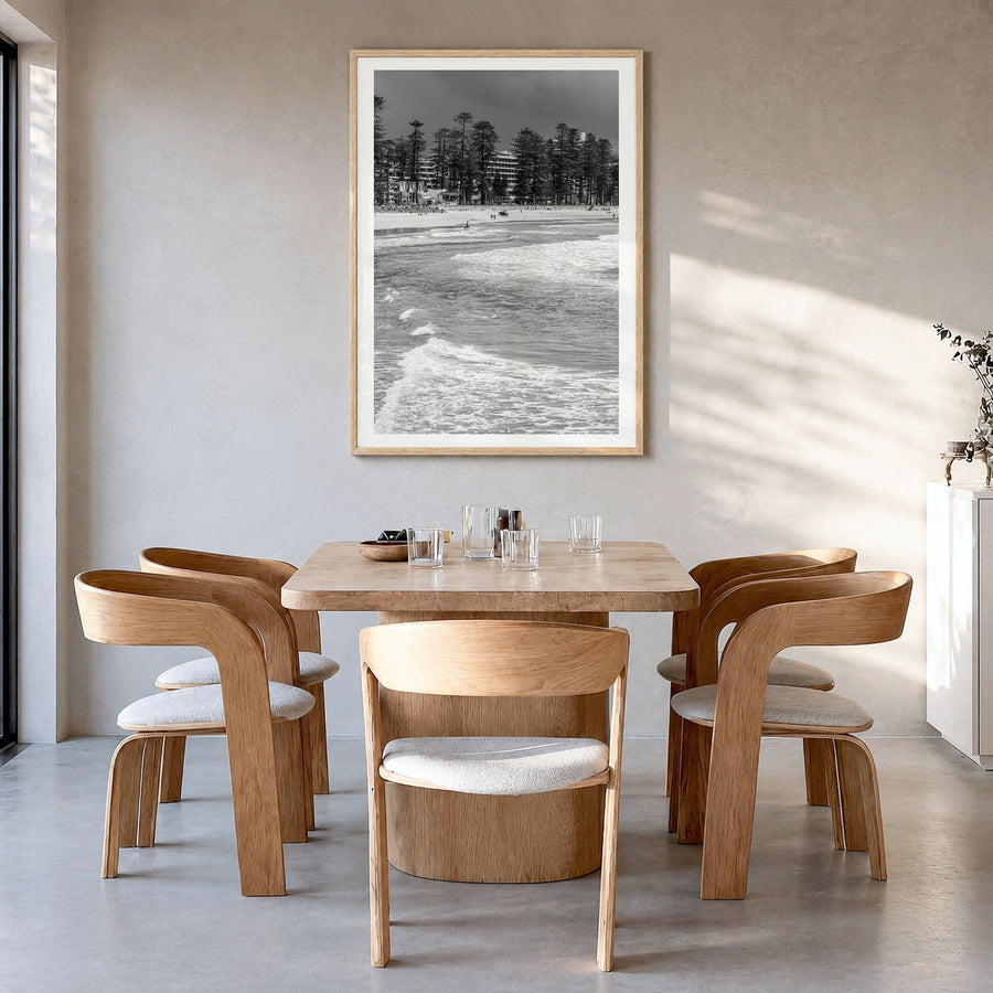 Manly Beach Photo Poster in a natural wood frame, hanging in a dining room, white border