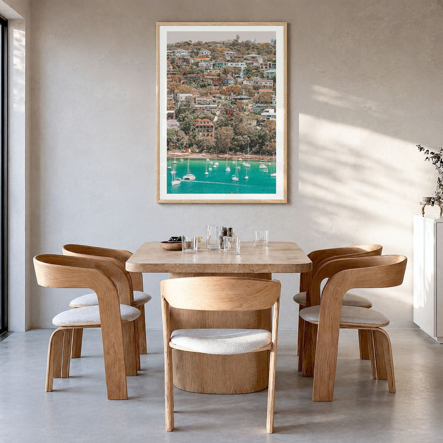 Manly Beach Photo Poster in a natural wood frame, hanging in a dining room, white border