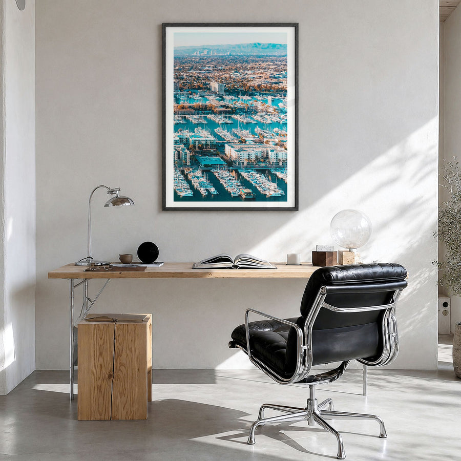 Marina del Rey Photo Poster in a black wood frame, hanging in a bright home office, white border