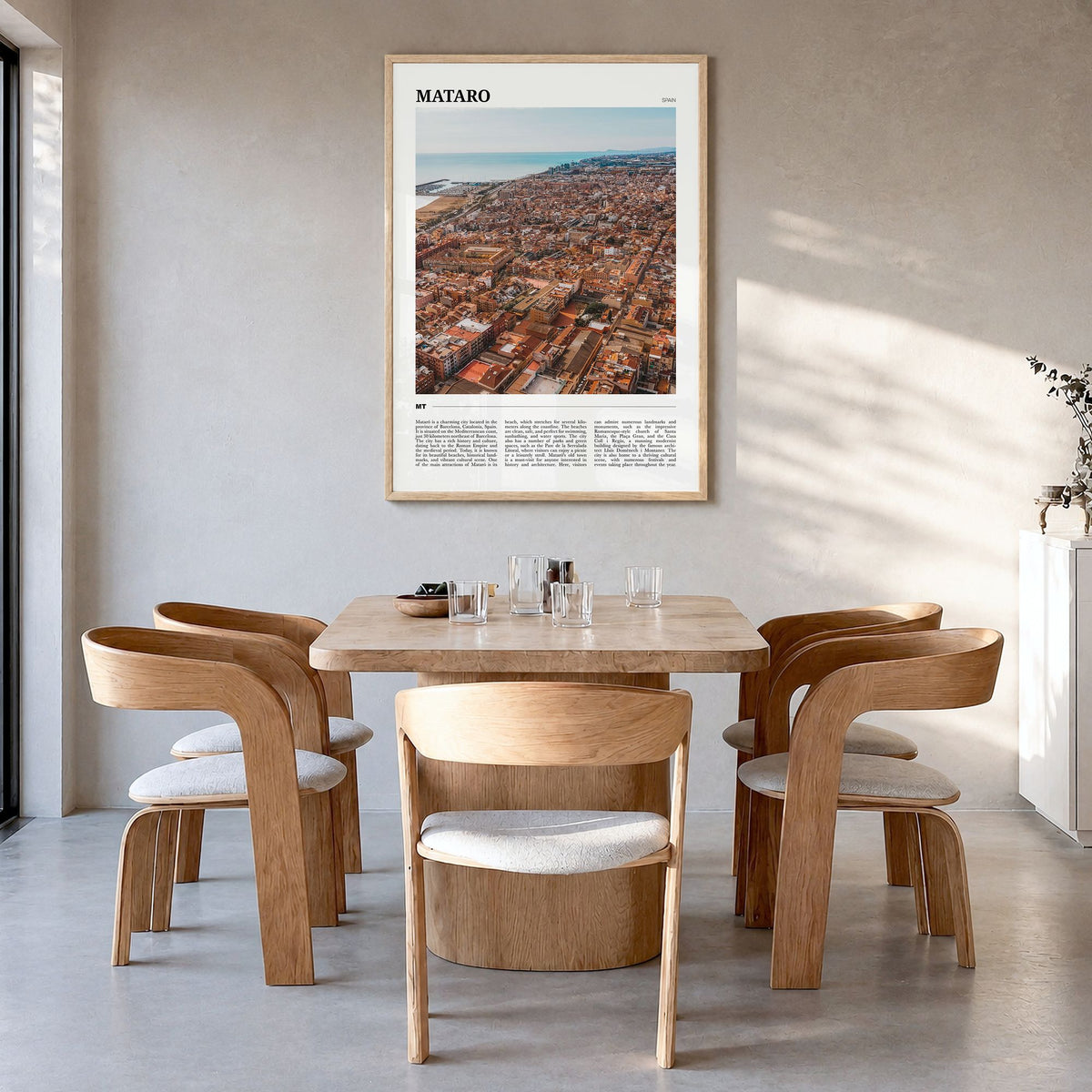 Mataró Travel Poster in a natural wood frame, hanging in a dining room