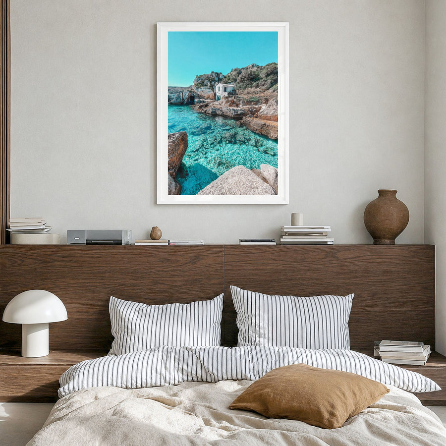 Menorca Photo Poster in a white wood frame, hanging in a bedroom, white border