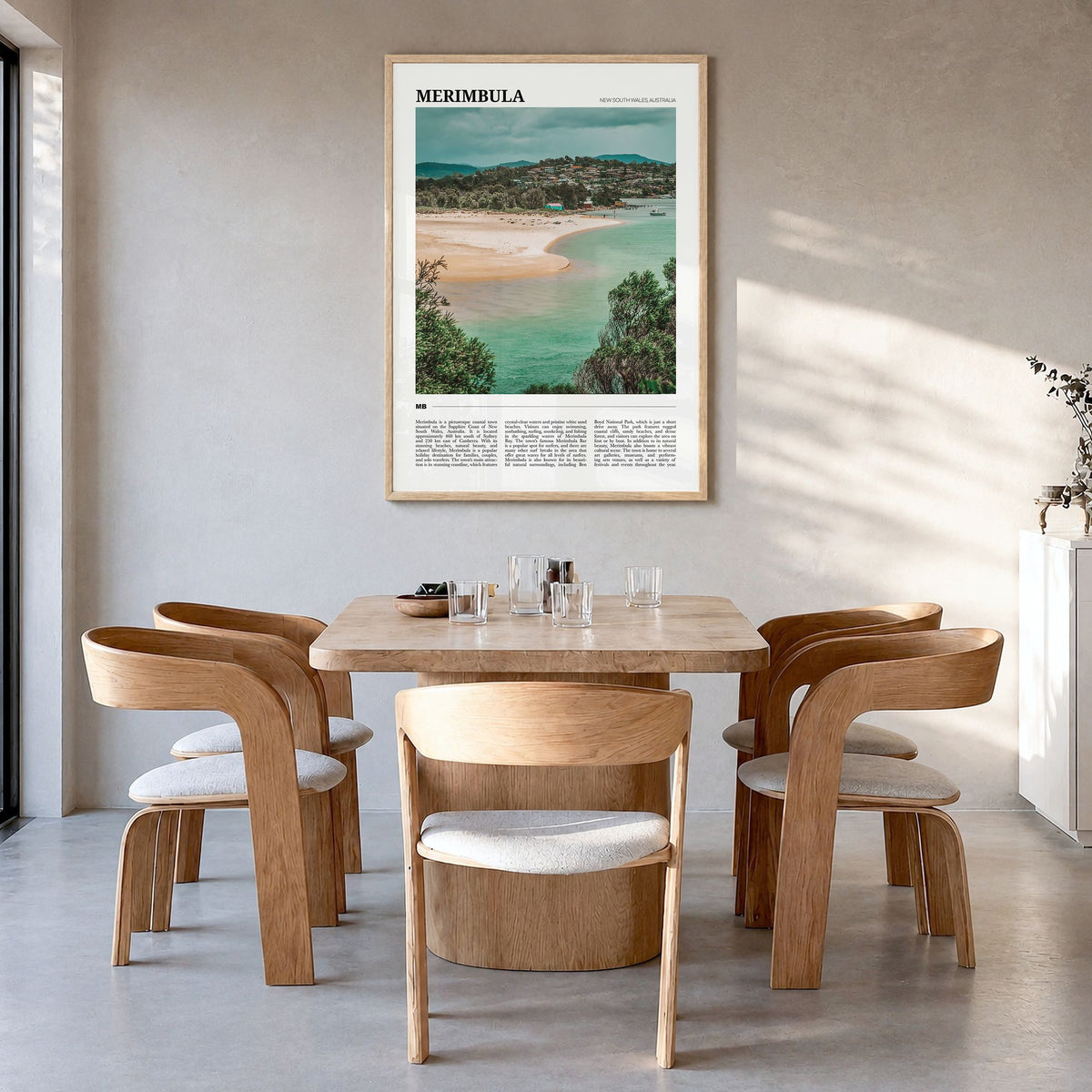 Merimbula Travel Poster in a natural wood frame, hanging in a dining room