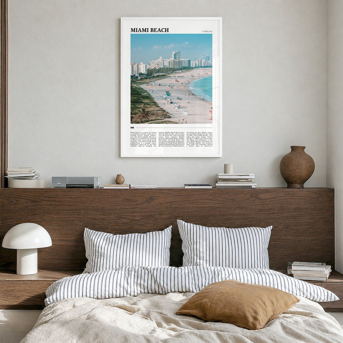 Miami Beach Travel Poster in a white wood frame, hanging in a bedroom