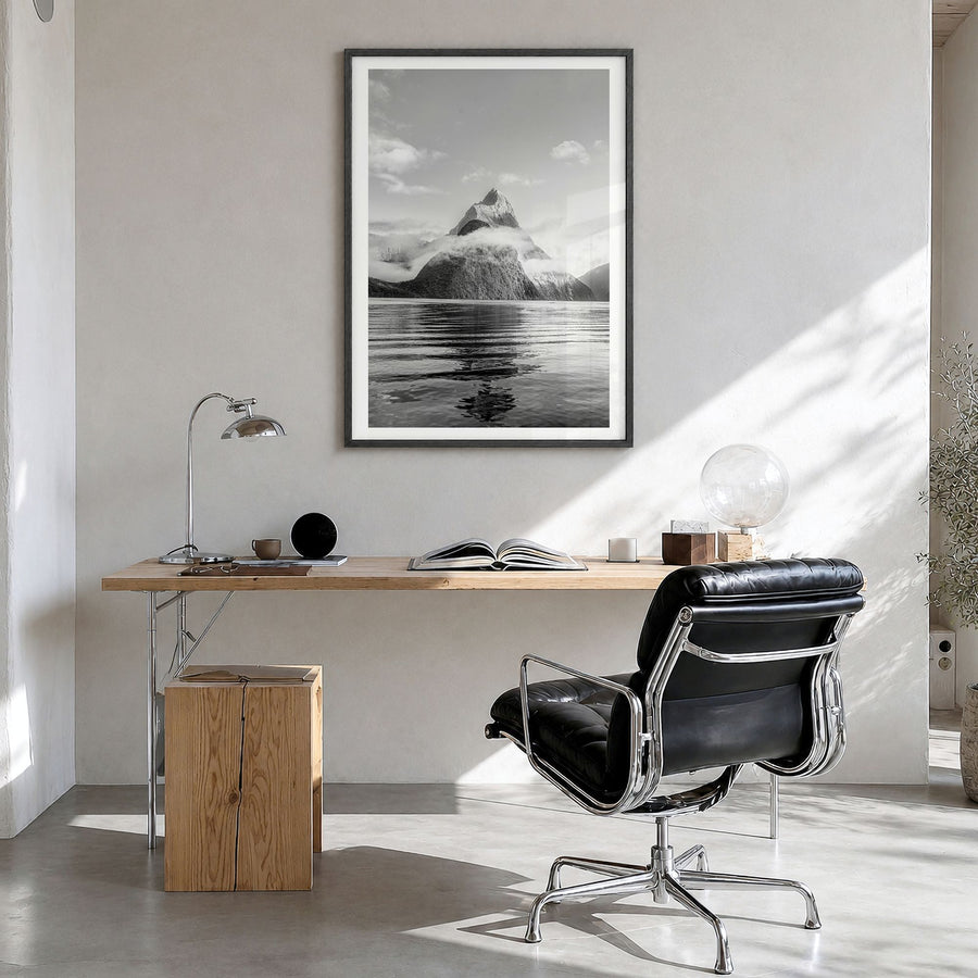 Milford Sound Photo Poster in a black wood frame, hanging in a bright home office, white border