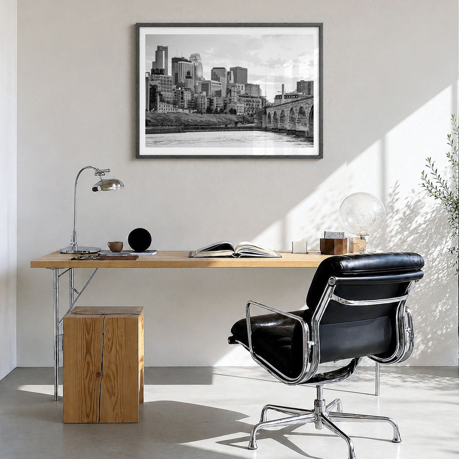 Minneapolis Photo Poster in a black wood frame, hanging in a bright home office, white border
