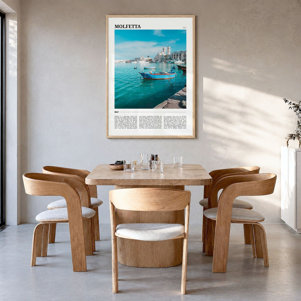 Molfetta Travel Poster in a natural wood frame, hanging in a dining room