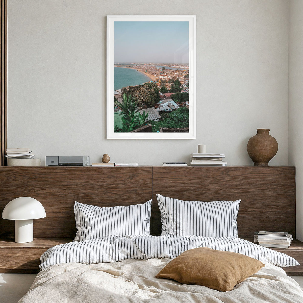 Monrovia Photo Poster in a white wood frame, hanging in a bedroom, white border
