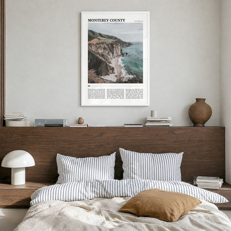 Monterey County Travel Poster in a white wood frame, hanging in a bedroom