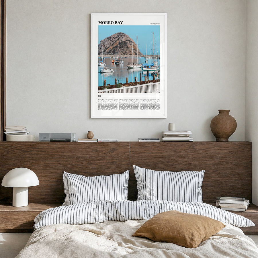 Morro Bay Travel Poster in a white wood frame, hanging in a bedroom