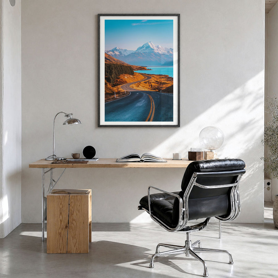 Mount Cook Photo Poster in a black wood frame, hanging in a bright home office, white border